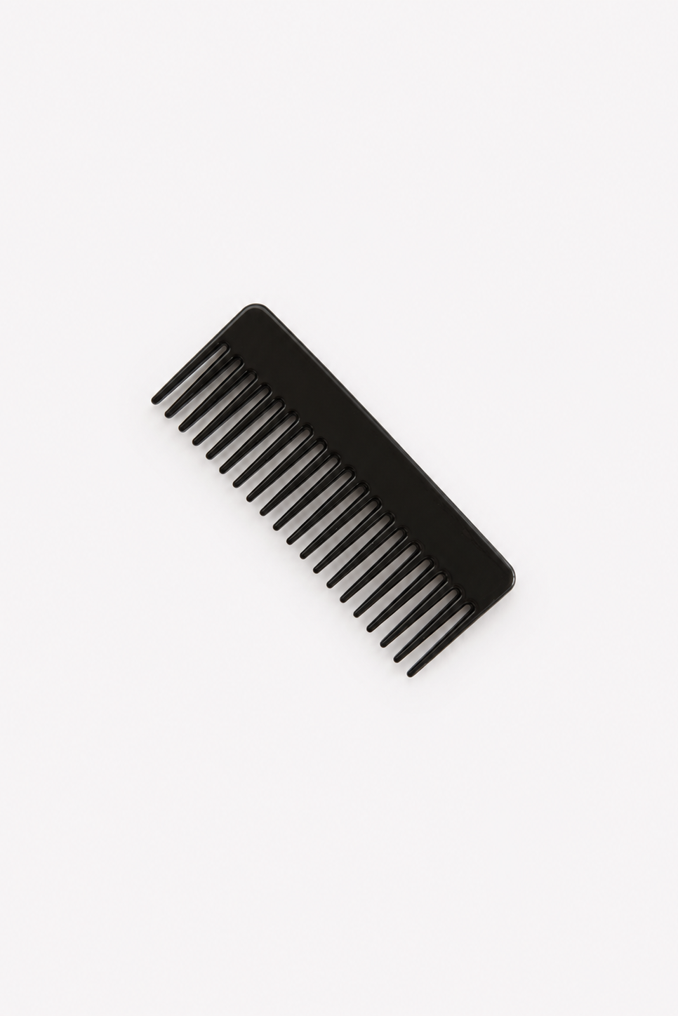 A black plastic wide-tooth comb shown diagonally on a clean, solid white background - East Coast General