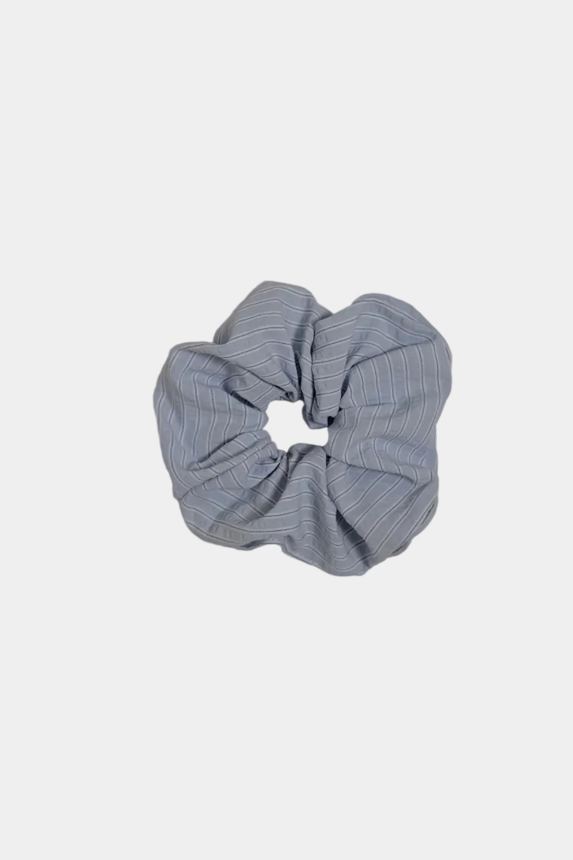 Blue scrunchie on a light gray surface