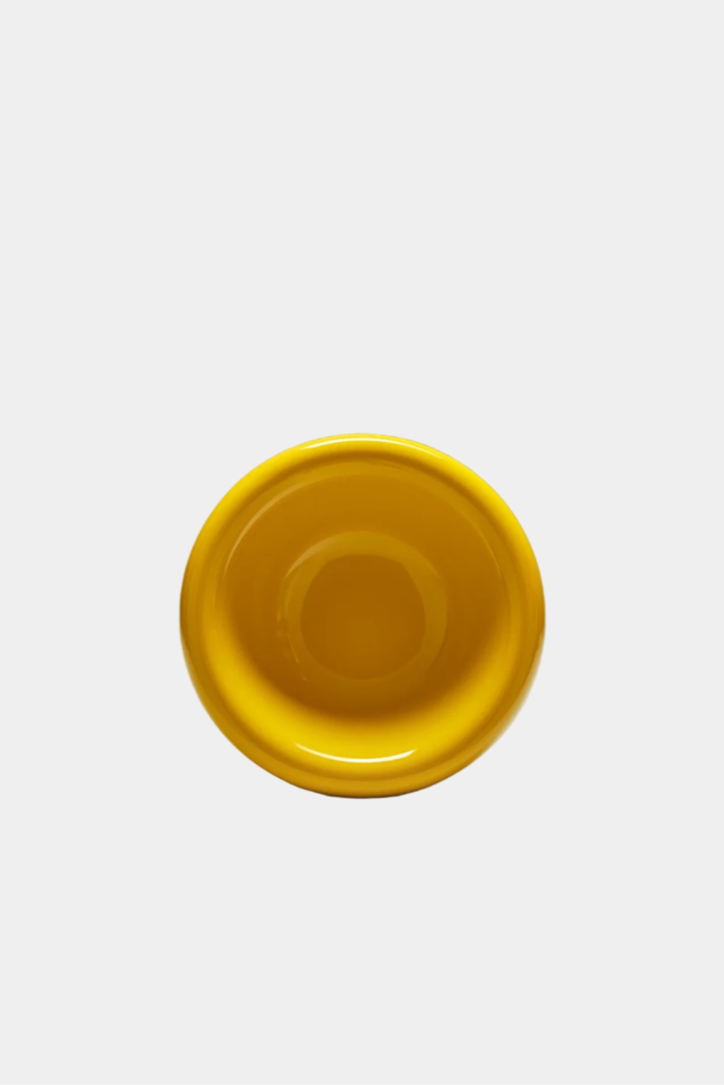 Mustard breakfast bowl on a white background, viewed from the side