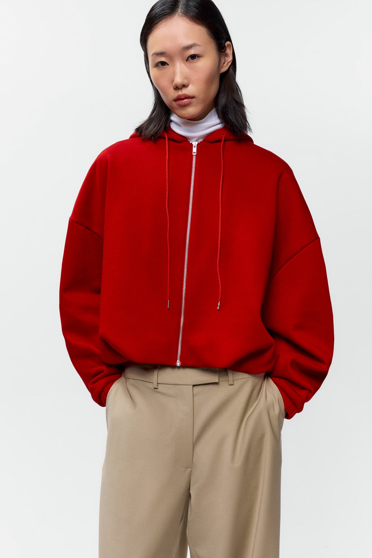 Front view of model wearing Cordera red balloon hoodie with silver zip closure - East Coast General
