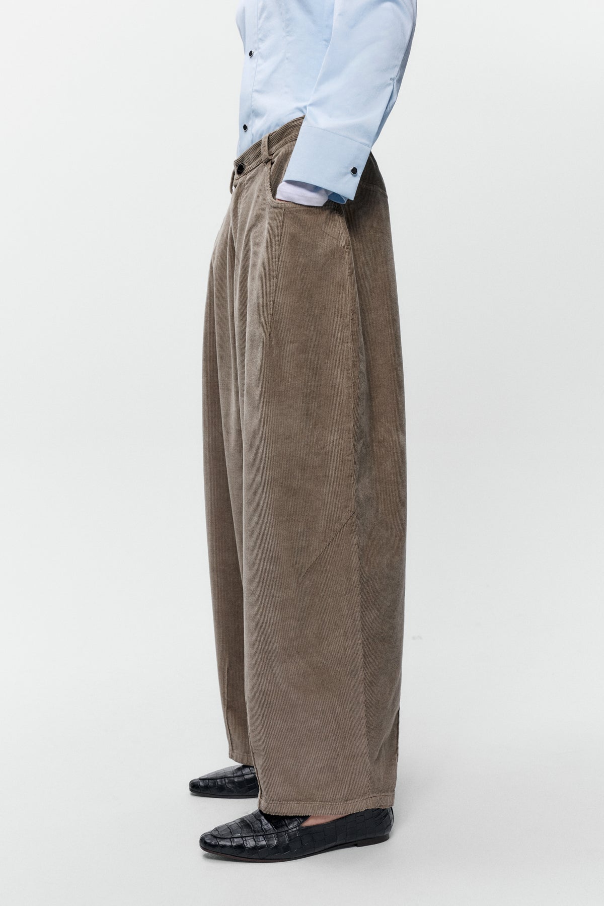 Close up side view of model wearing Cordera corduroy baggy pants in sage with wide leg fit - East Coast General