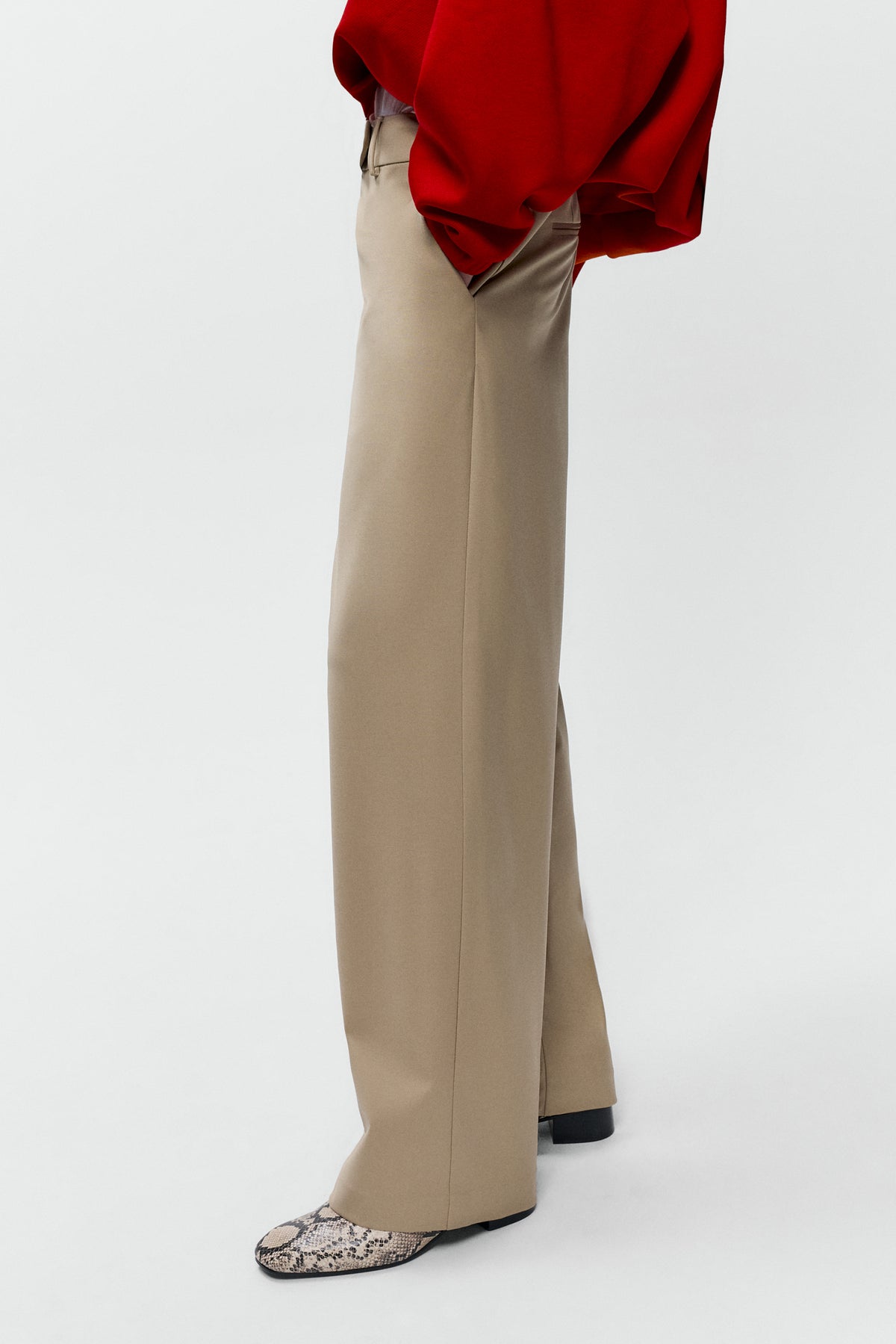 Side view of model wearing Cordera low rise virgin wool pants in beige with straight leg fit - East Coast General