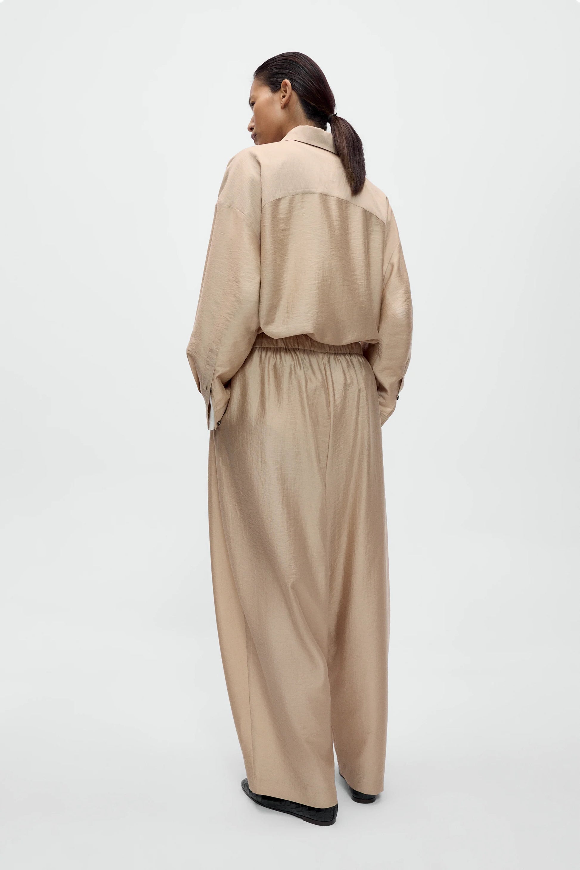 Woman wearing a beige outfit on a white background