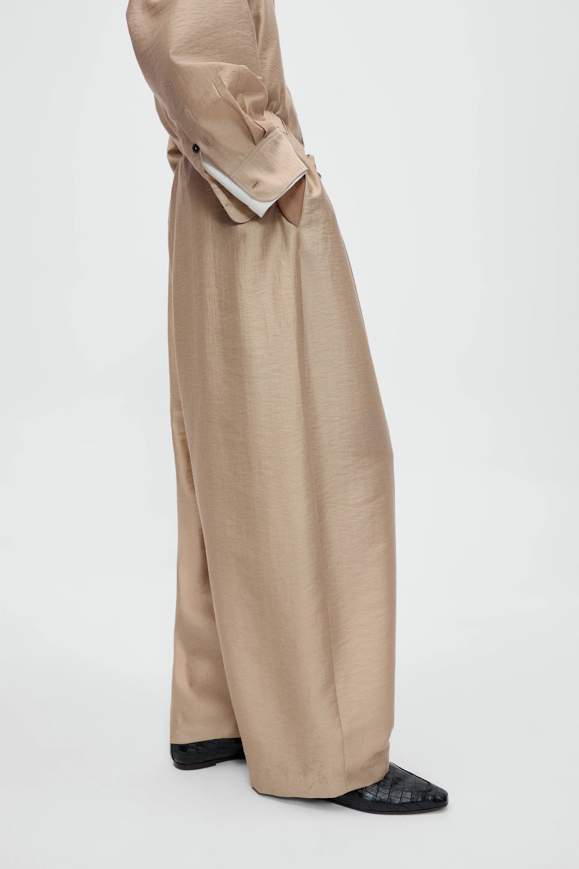 Beige trench coat with wide-leg pants on a white background