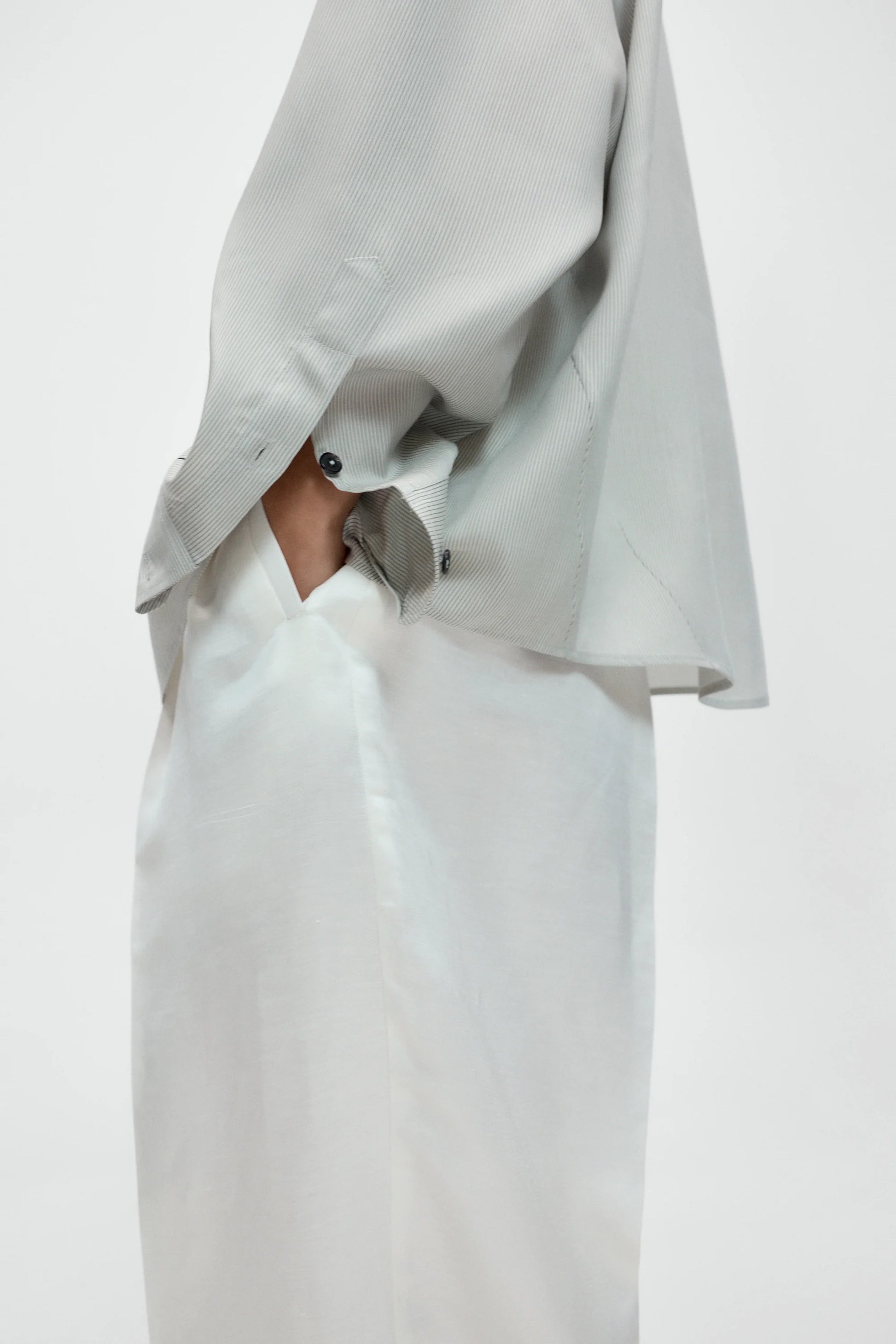 Light gray jacket over a white dress on a plain background
