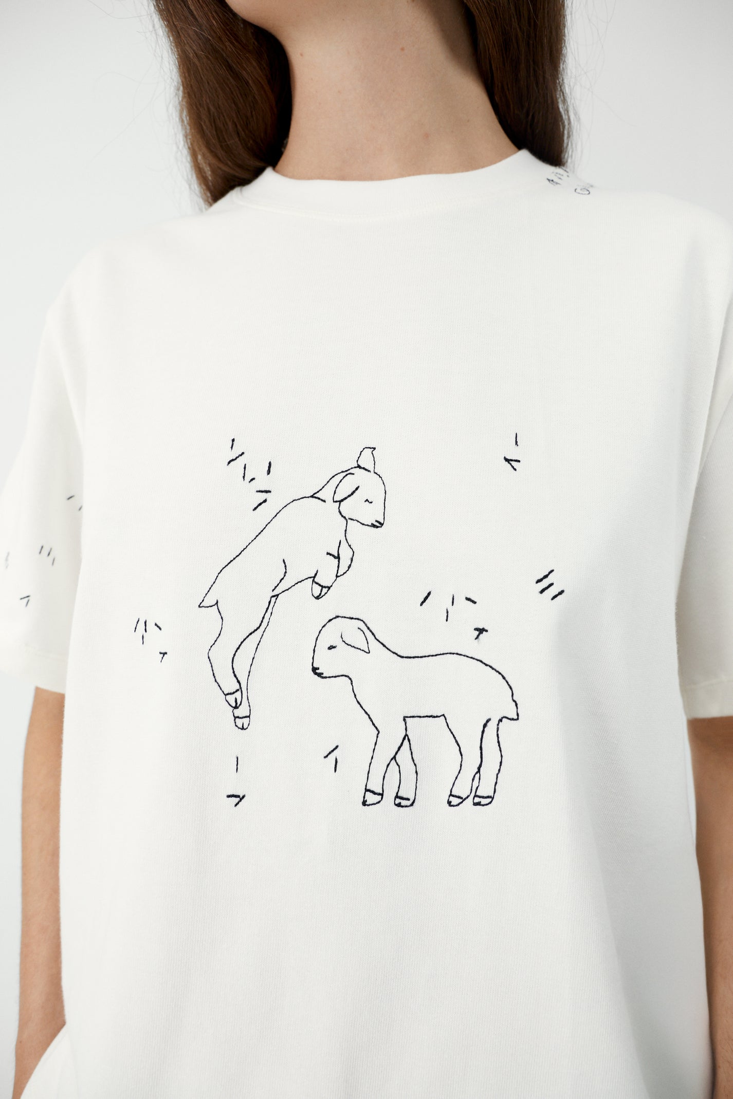 White t-shirt with embroidered lamb illustration on a plain background