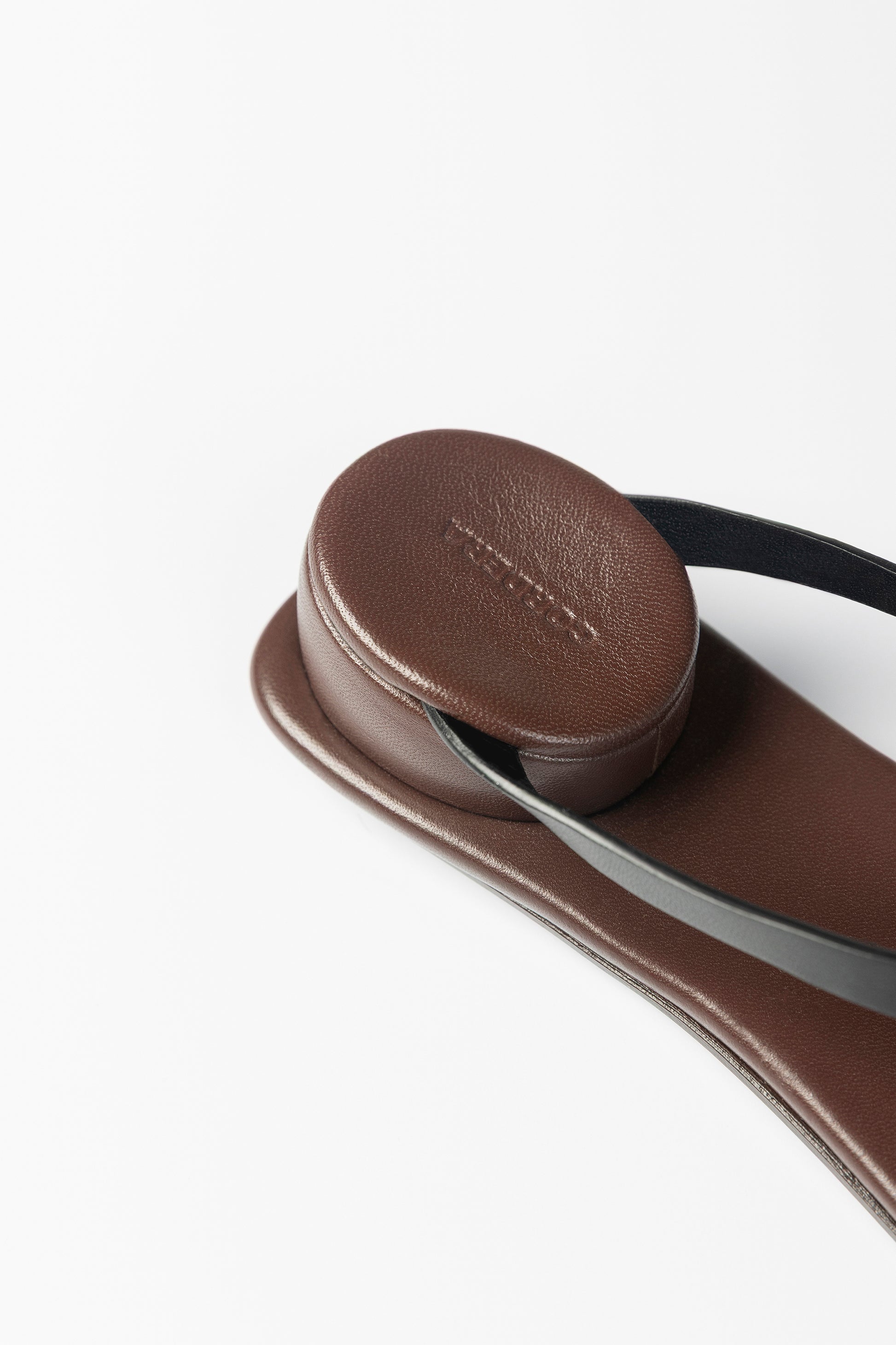 Brown sandal with a circular strap on a white background