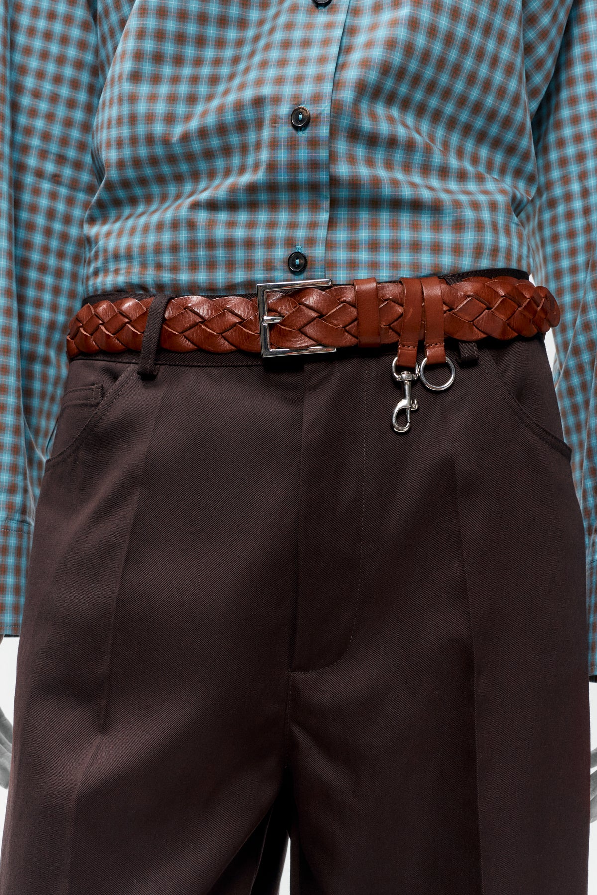 Cordera Woven Belt in tan braided leather flat lay with silver buckle and carabiner ring styled with a plaid shirt and brown trousers - East Coast General