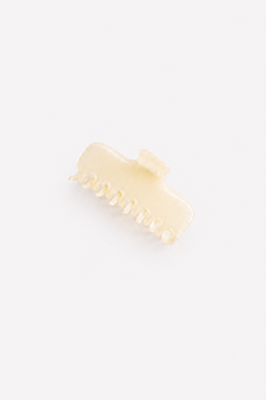 A small cream-colored plastic claw hair clip on a solid white background - East Coast General