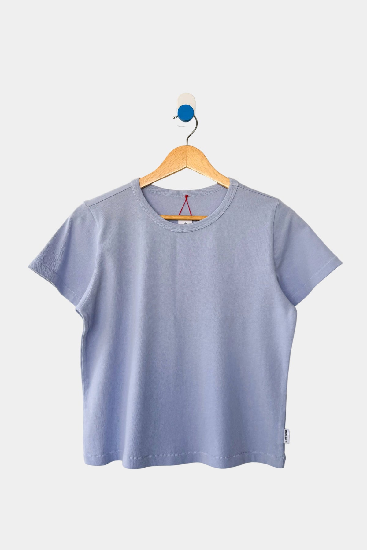 Le Bon Shoppe Little Boy tee in Serenity displayed on a wooden hanger - East Coast General