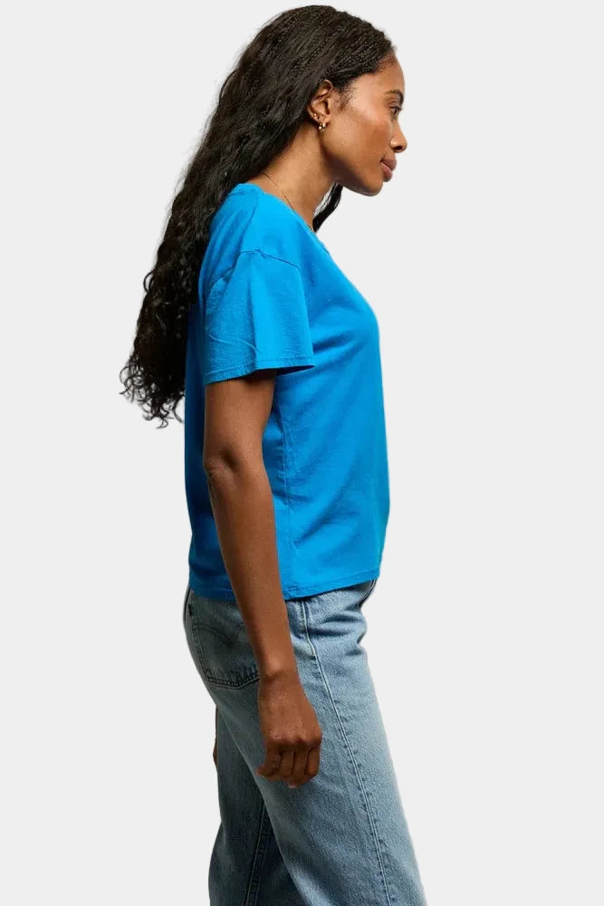Person wearing a blue t-shirt and jeans against a plain background