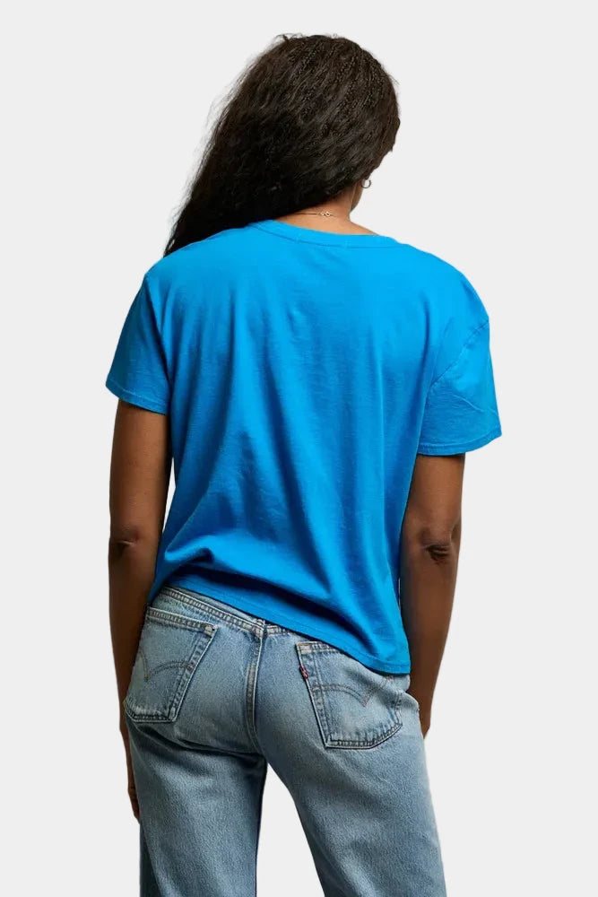 Person wearing a blue t-shirt and jeans against a plain background