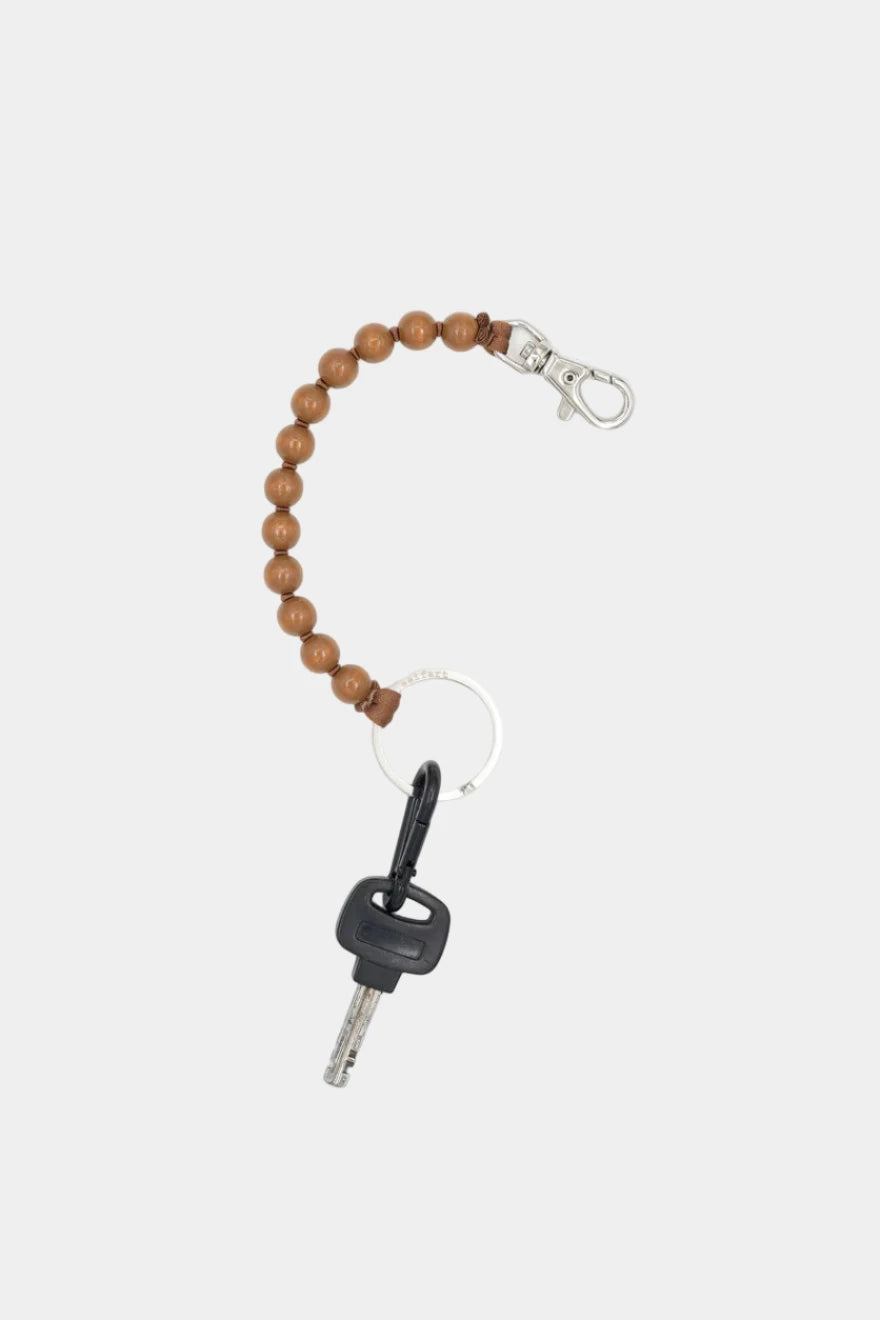 Wooden beaded keychain with a key on a white background