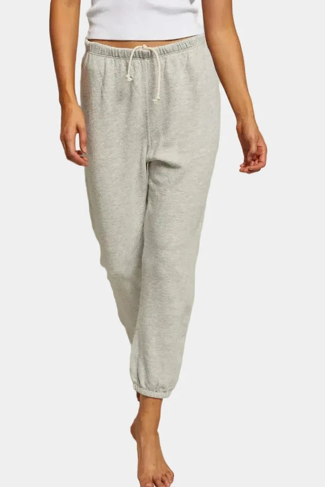 Person wearing gray sweatpants on a plain background