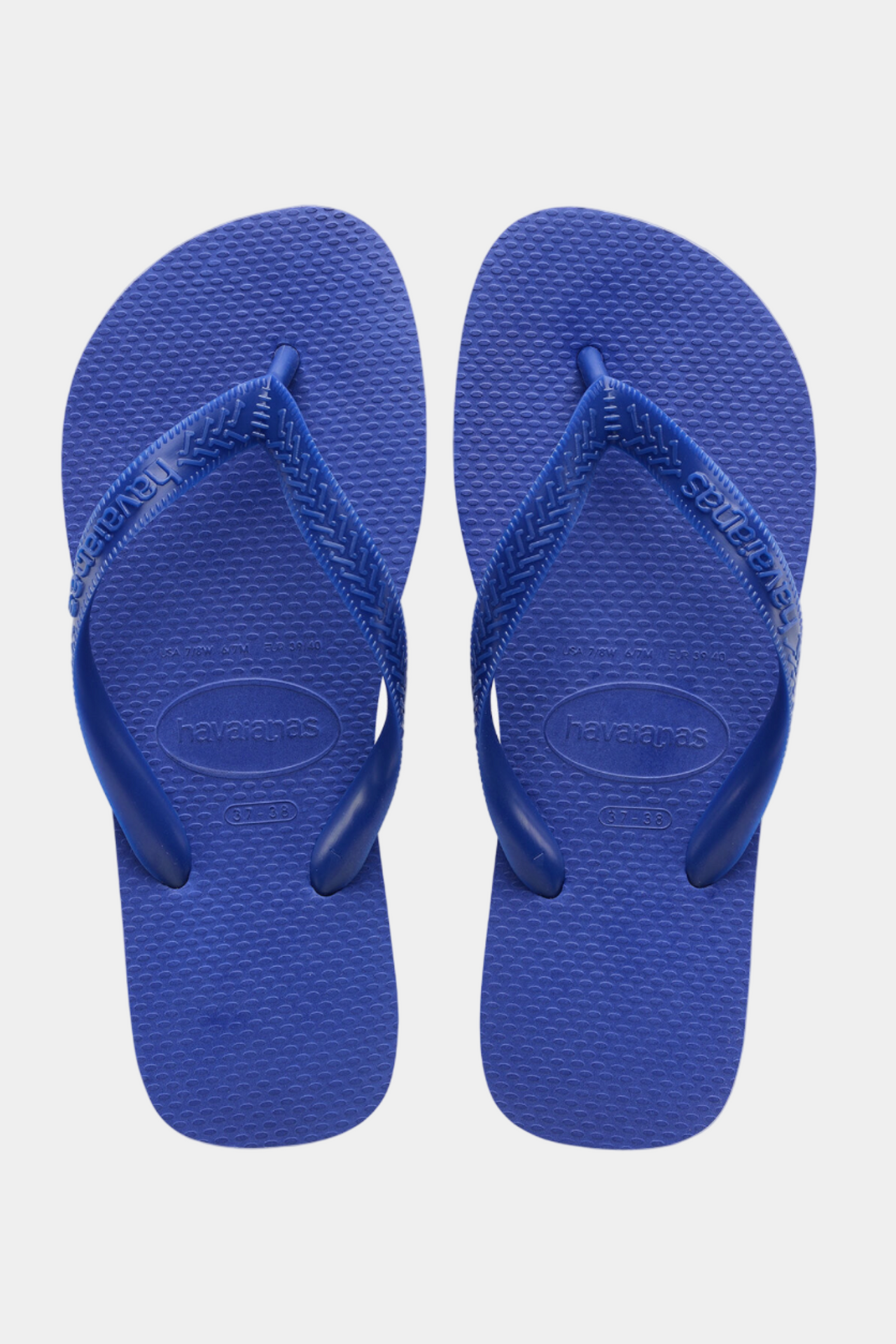 Pair of blue flip-flops on a light gray background