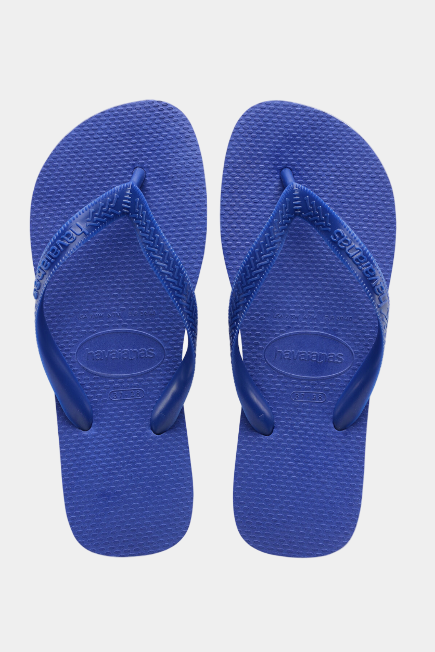 Pair of blue flip-flops on a light gray background