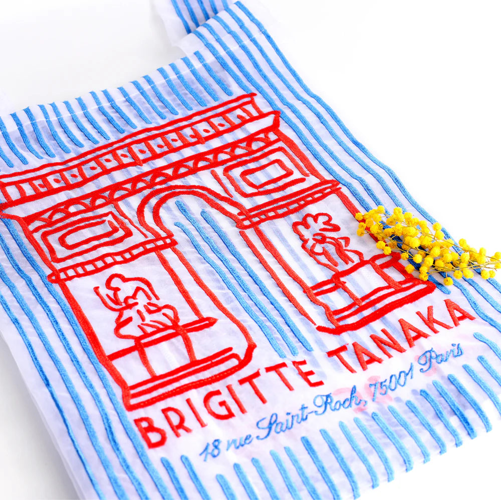 Striped towel with red Arc de Triomphe design and 'Brigette Tanaka' text on a white background