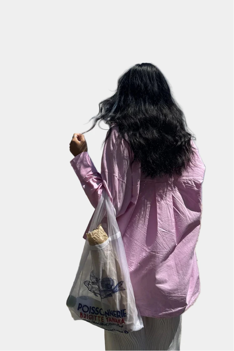 Person in pink jacket with a white bag against a white background