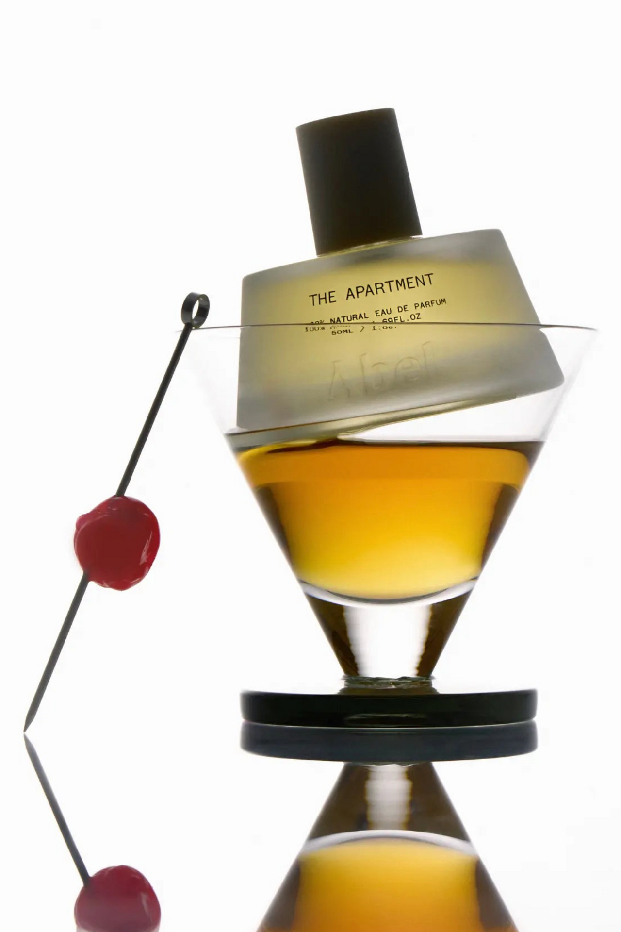 Perfume bottle labeled 'The Apartment' on a white background