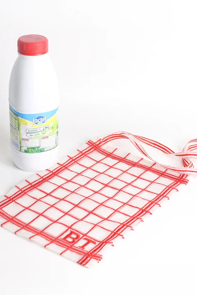 red embroidered check bag with a milk bottle on a white background