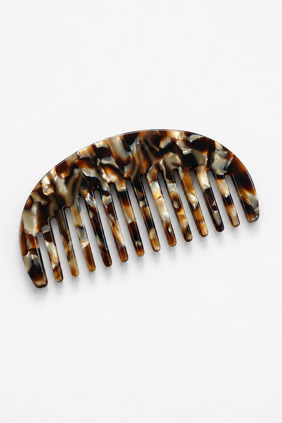Tortoiseshell-patterned hair comb on a white background