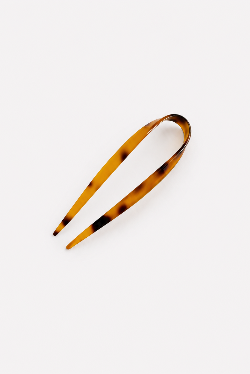 A single tortoiseshell French hair pin on a clean, light gray background - East Coast General